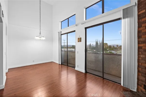 a view of a big room with wooden floor and windows