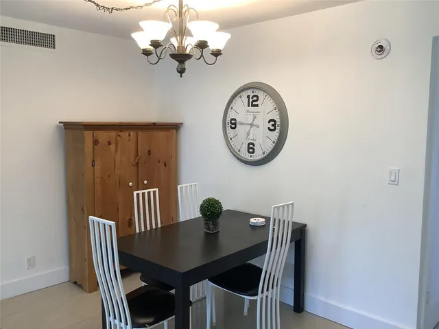 a view of a dining room with furniture a chandelier and a wooden floor