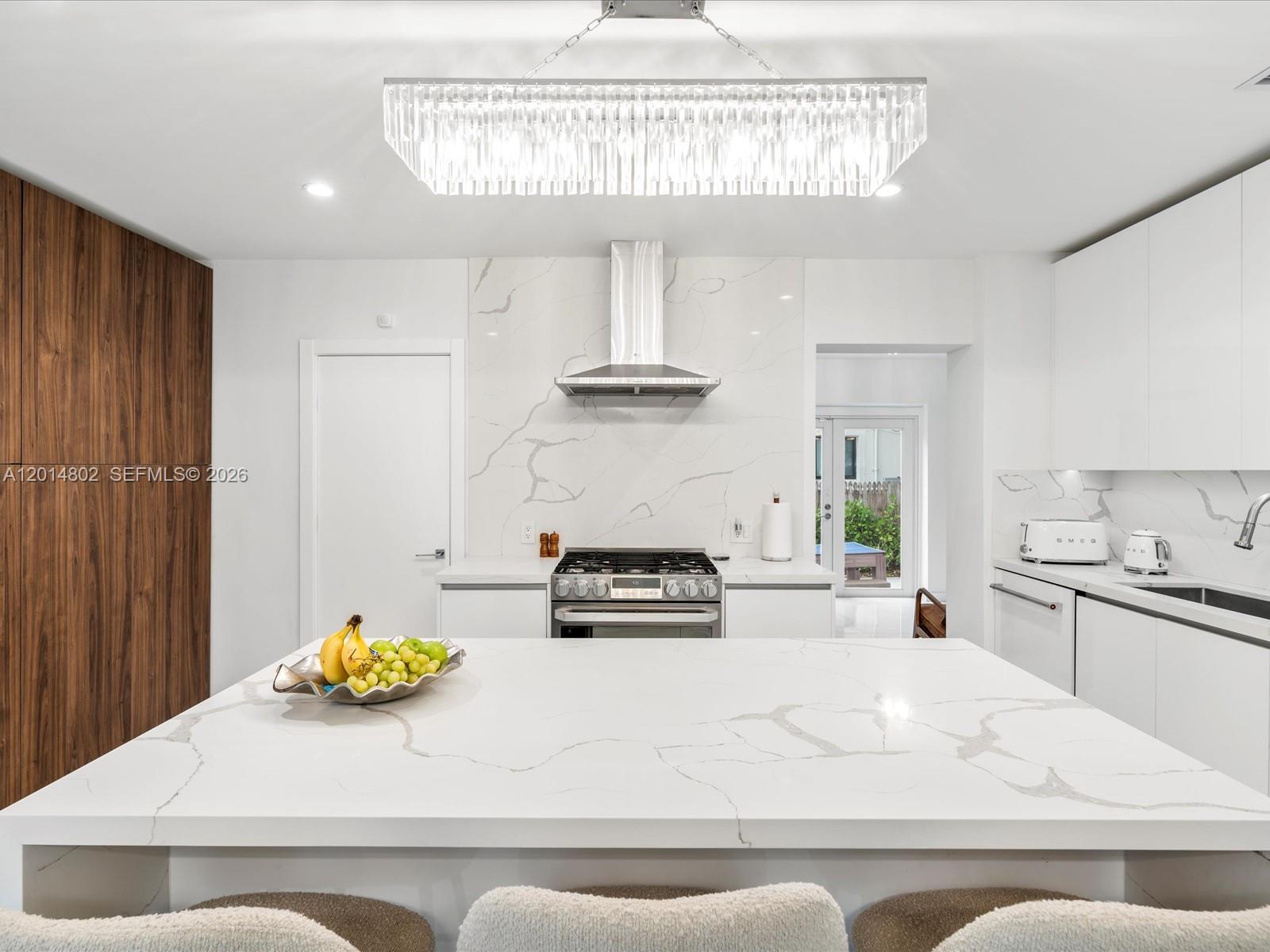 825 Southwest 23rd Road, Unit 1 Miami, FL 33129 - Photo 51 of 92 a kitchen with a stove a chandelier and a table