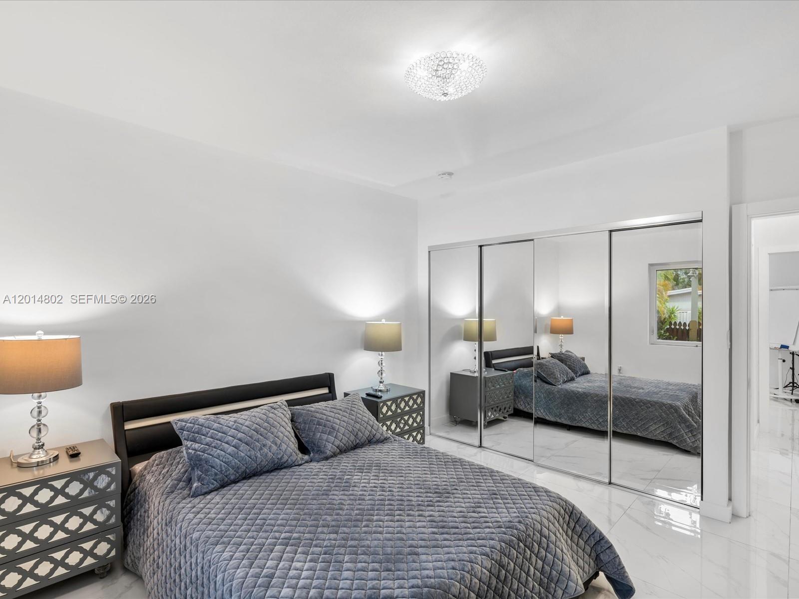 825 Southwest 23rd Road, Unit 1 Miami, FL 33129 - Photo 59 of 92 a bedroom with a bed and lamp