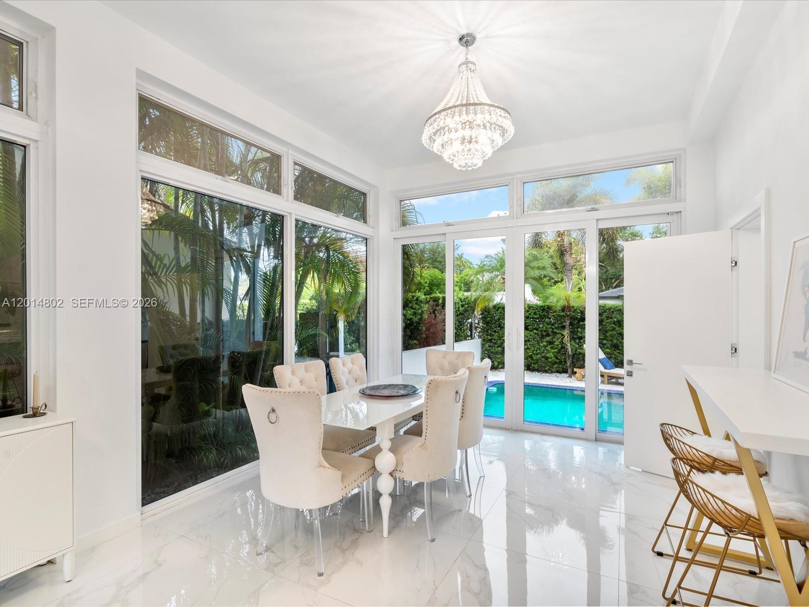 825 Southwest 23rd Road, Unit 1 Miami, FL 33129 - Photo 68 of 92 a dining room with furniture a chandelier and wooden floor