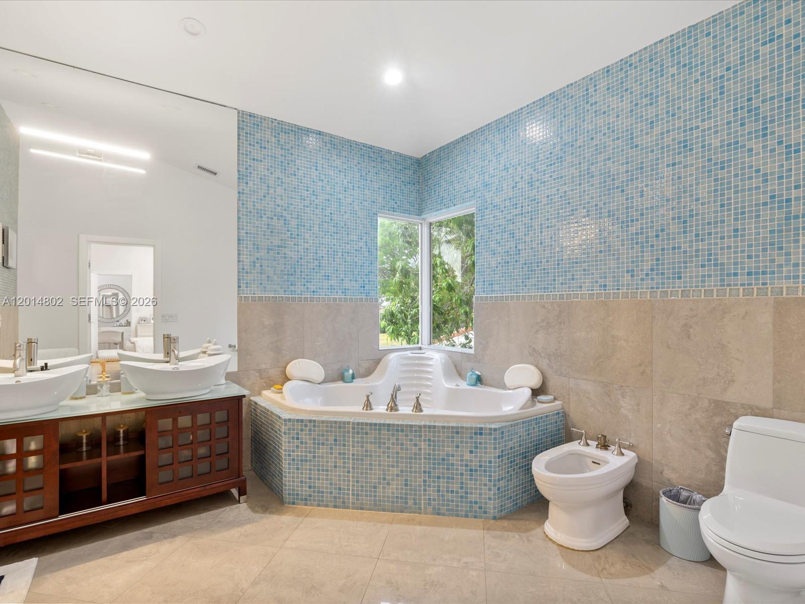 825 Southwest 23rd Road, Unit 1 Miami, FL 33129 - Photo 85 of 92 a bathroom with a granite countertop toilet a sink and a bathtub