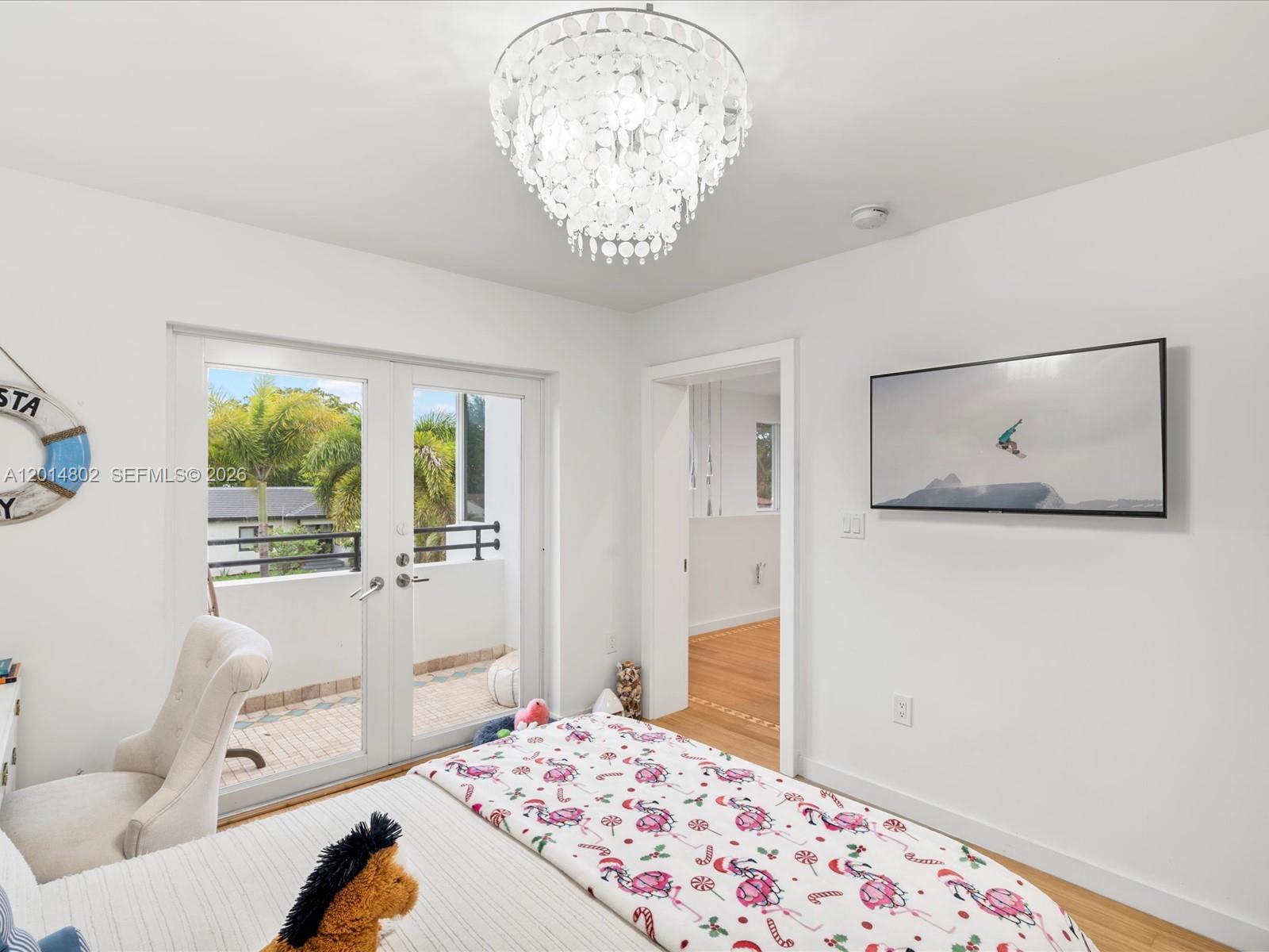 825 Southwest 23rd Road, Unit 1 Miami, FL 33129 - Photo 88 of 92 a bedroom with a bed and a chandelier