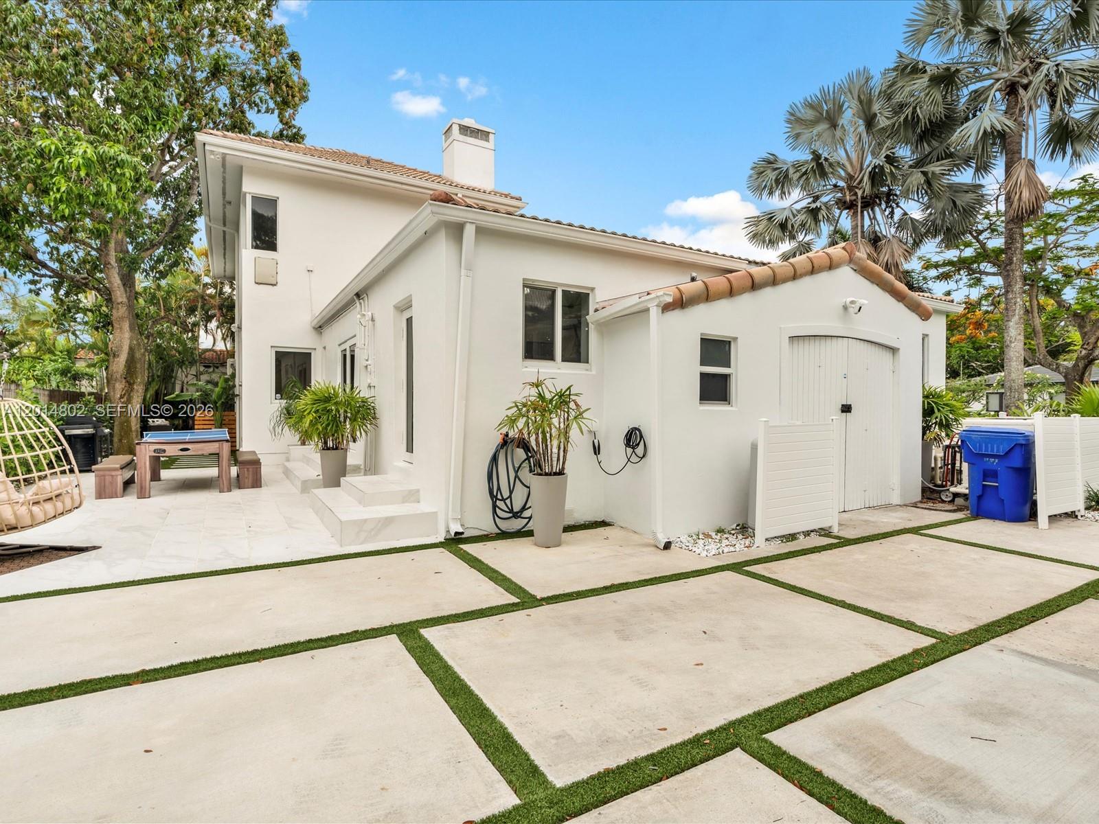825 Southwest 23rd Road, Unit 1 Miami, FL 33129 - Photo 10 of 92 a white house with potted plants in front of it