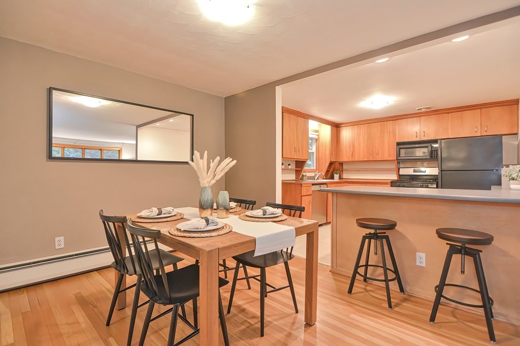 3 Smart Road Acton, MA 01720 - Photo 9 of 23 a dining room with stainless steel appliances kitchen island granite countertop a dining table and chairs with wooden floor