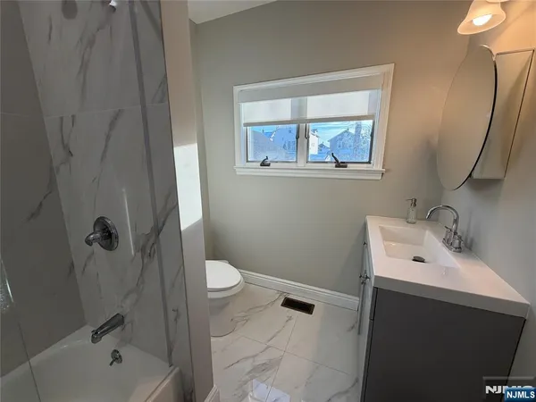 a bathroom with a sink mirror toilet and bathtub