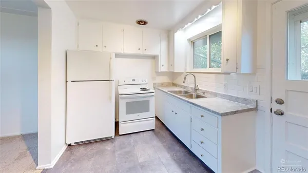 a kitchen with granite countertop white cabinets and white appliances