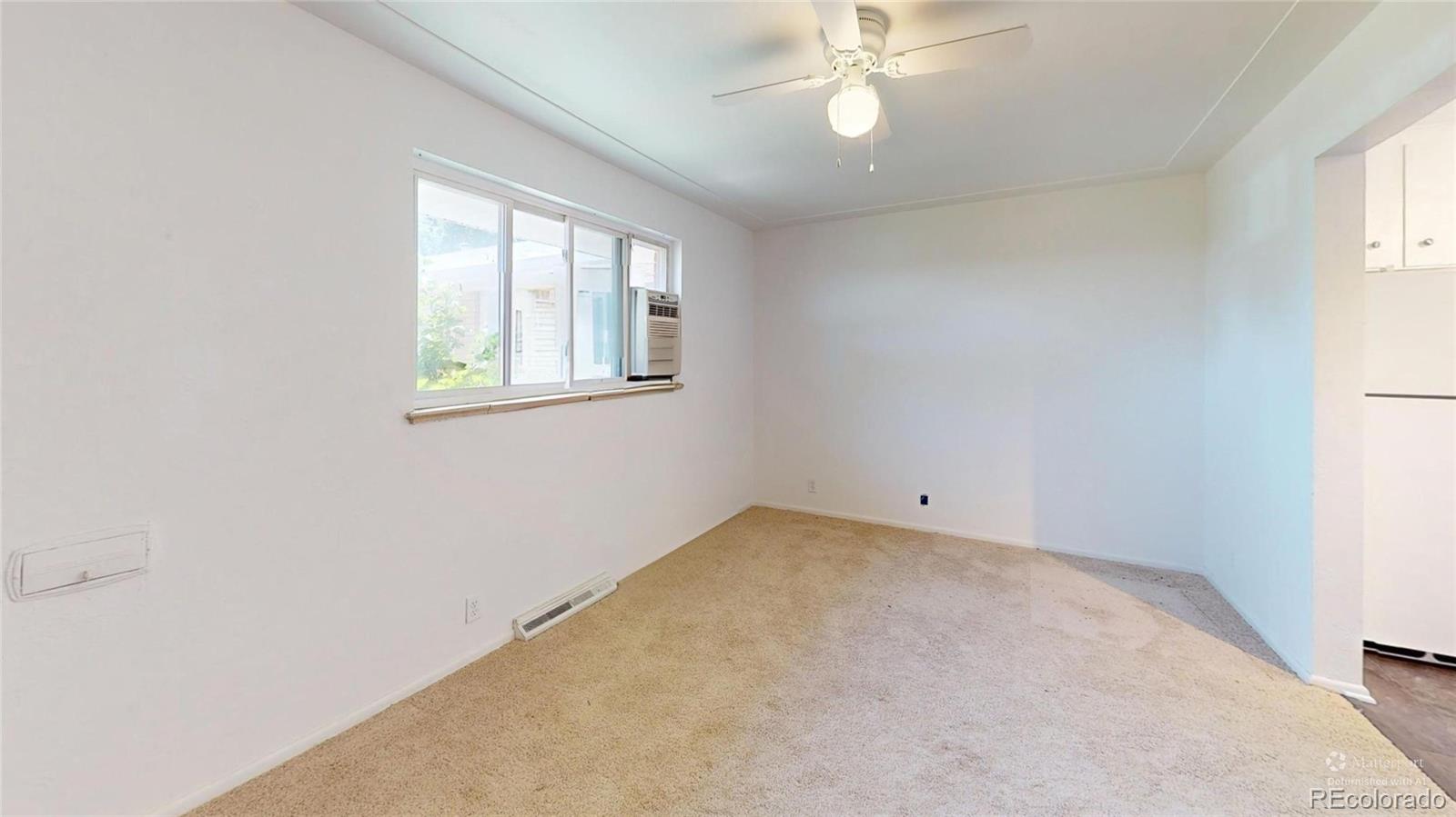 7805 West 41st Avenue, Unit 4 Wheat Ridge, CO 80033 - Photo 8 of 17 an empty room with windows and fan