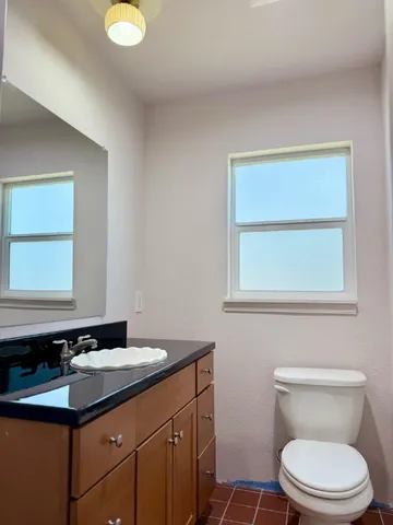 a bathroom with a sink a toilet and a mirror