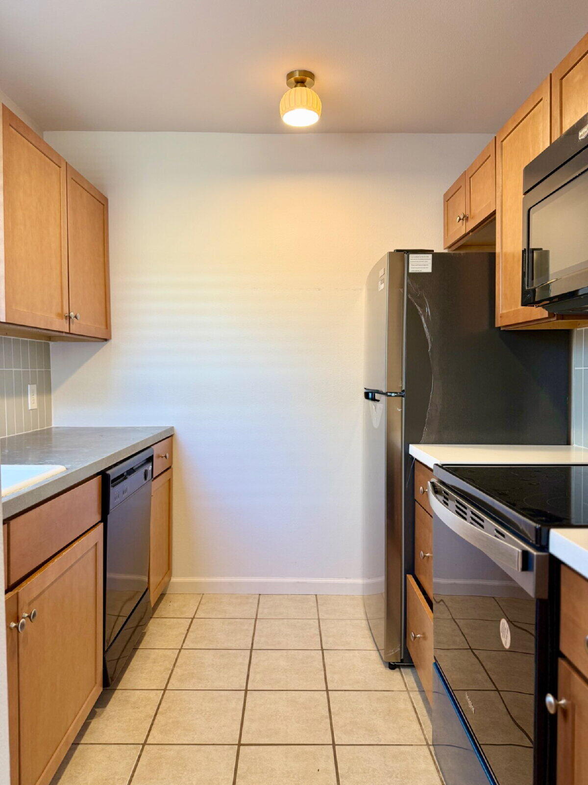 3118 37th Street, Unit B Lubbock, TX 79413 - Photo 6 of 21 a kitchen with a refrigerator and cabinets