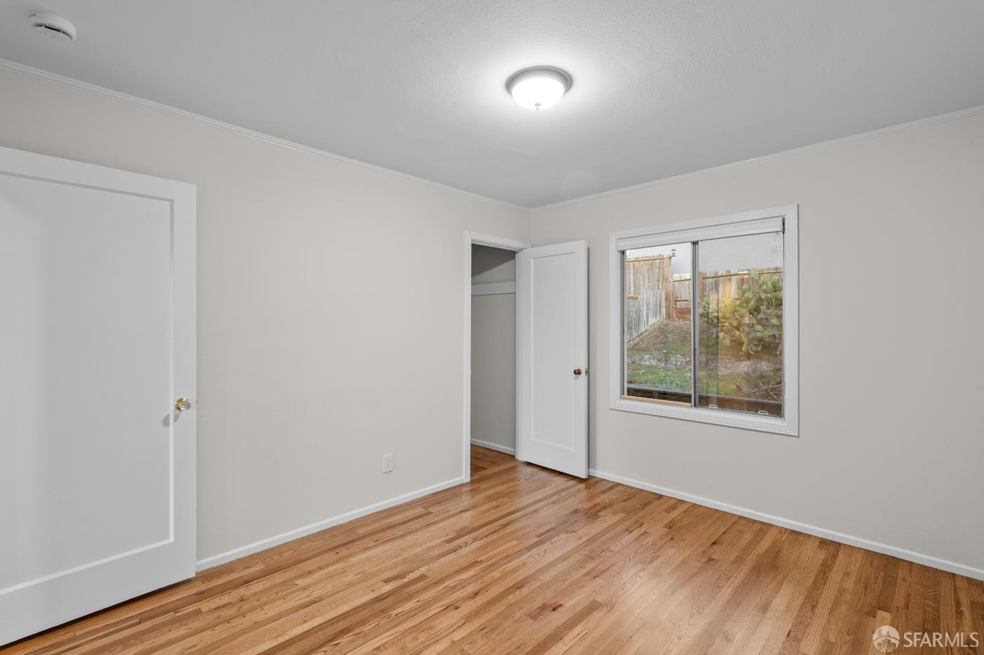 193 Hillside Boulevard Daly City, CA 94014 - Photo 10 of 20 a view of an empty room with wooden floor and a window