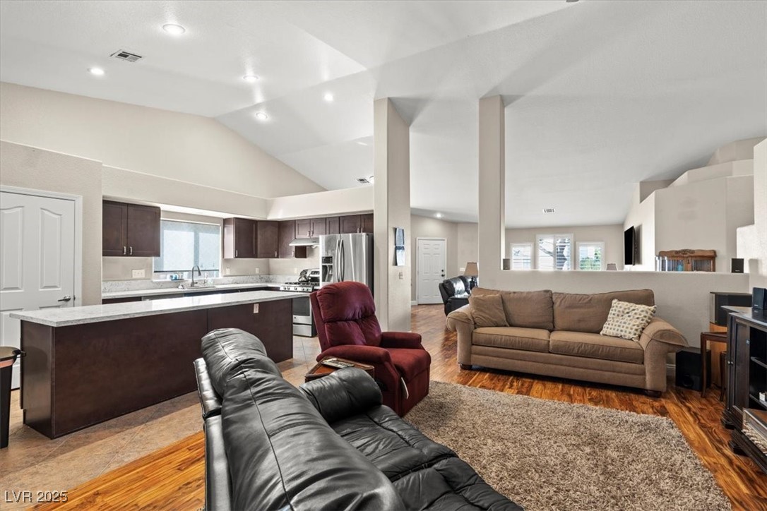 9031 West Viking Road Las Vegas, NV 89147 - Photo 13 of 33 Living room with high vaulted ceiling, visible vents, and light wood-type flooring