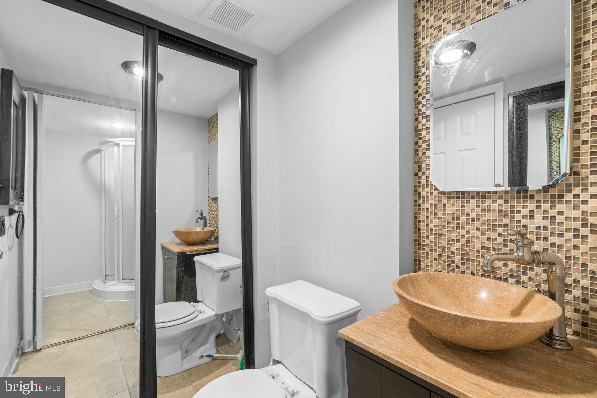 8583 Seasons Way Lanham, MD 20706 - Photo 12 of 25 a bathroom with a toilet a sink and mirror