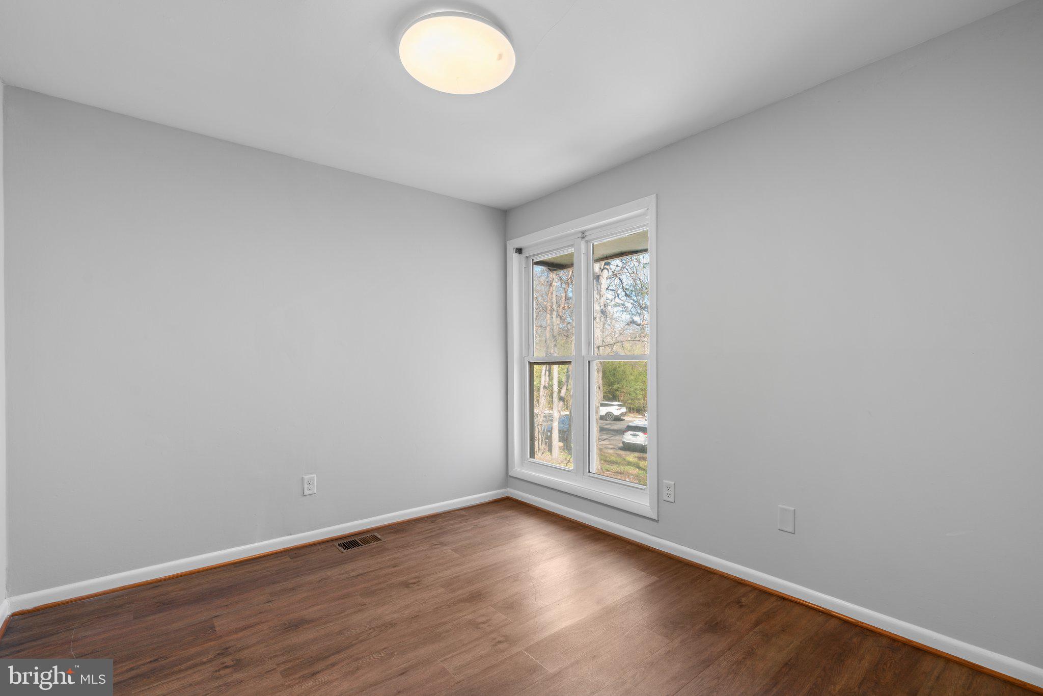 8583 Seasons Way Lanham, MD 20706 - Photo 13 of 25 an empty room with wooden floor and windows