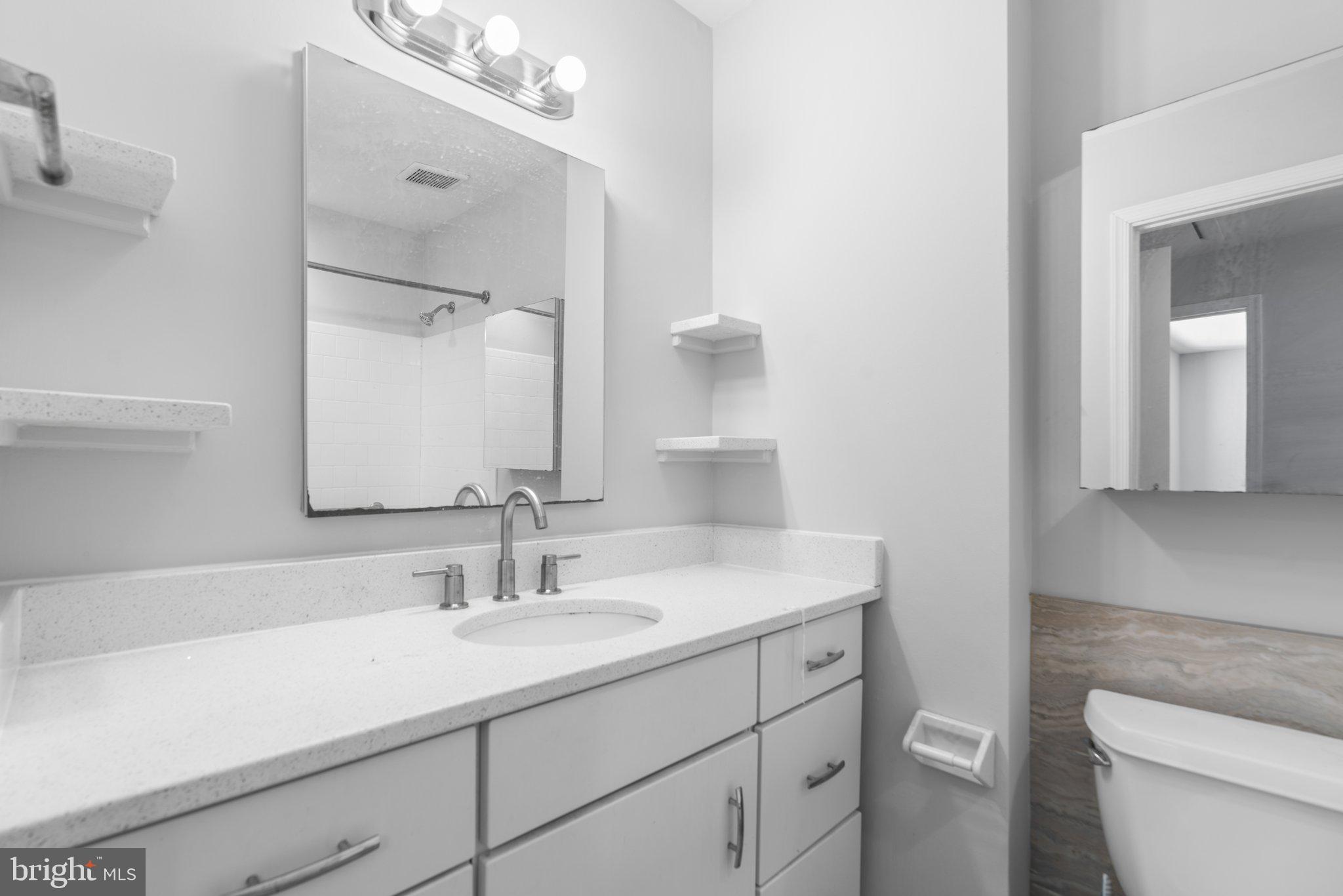 8583 Seasons Way Lanham, MD 20706 - Photo 14 of 25 a bathroom with a sink a toilet and a mirror