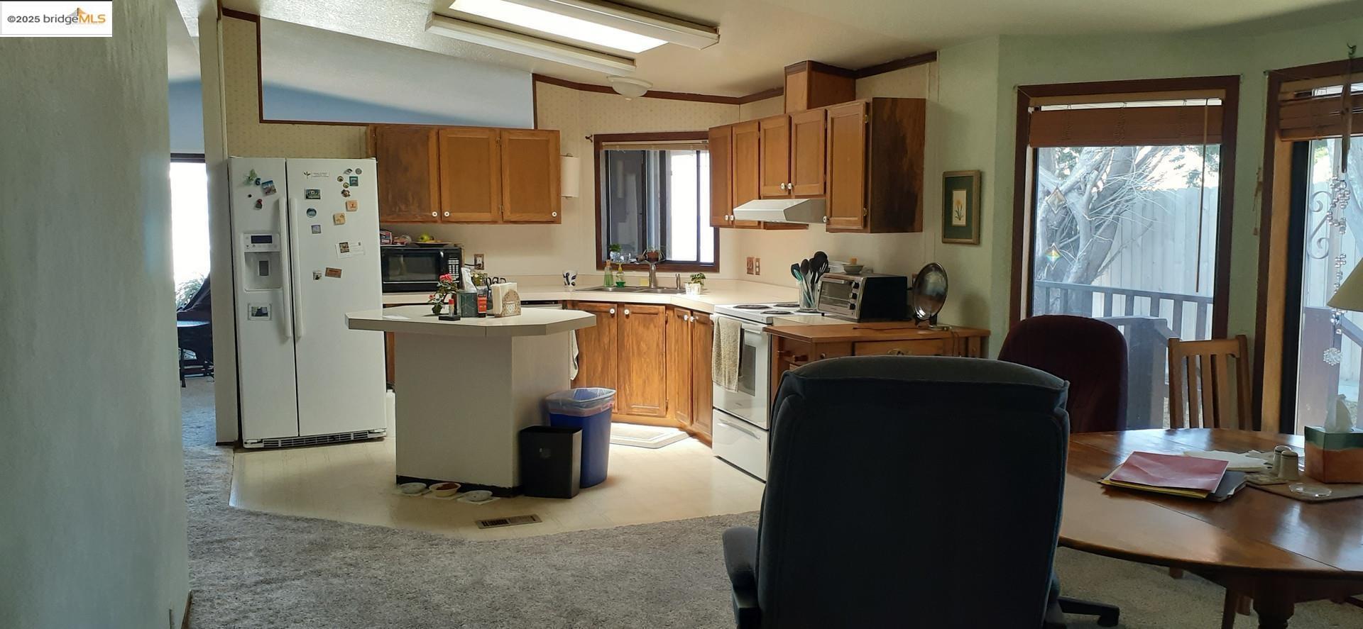 136 Castle Court Fortuna, CA 95540 - Photo 5 of 31 a kitchen with a refrigerator and a table