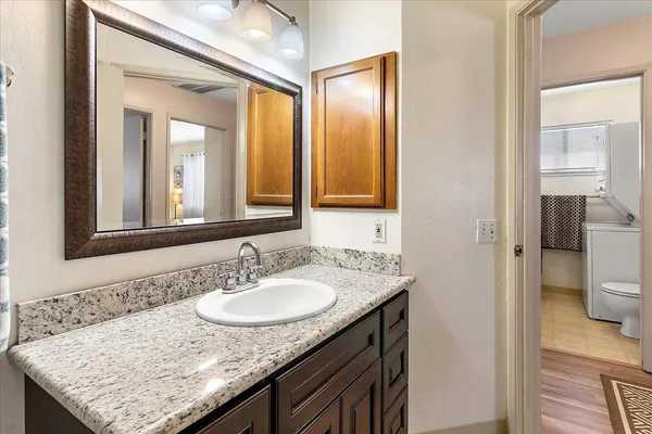 a bathroom with a granite countertop sink and a mirror