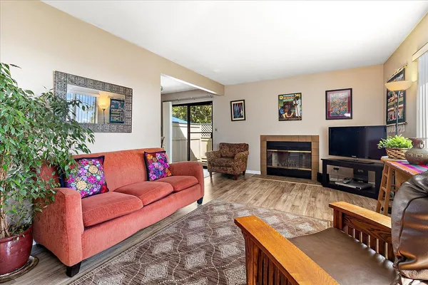 a living room with furniture a flat screen tv and a fireplace