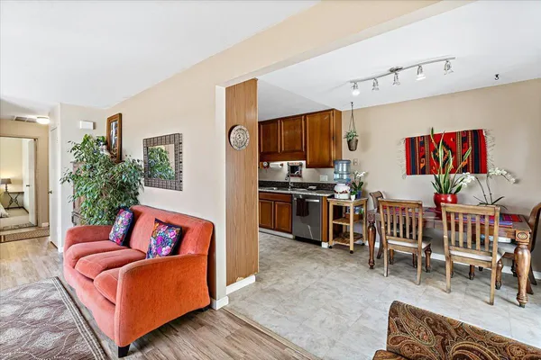 a living room with furniture a flat screen tv and kitchen view