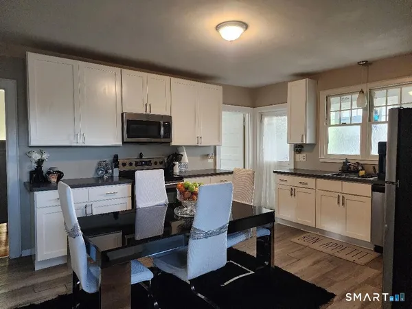 a kitchen with a dining table chairs and refrigerator