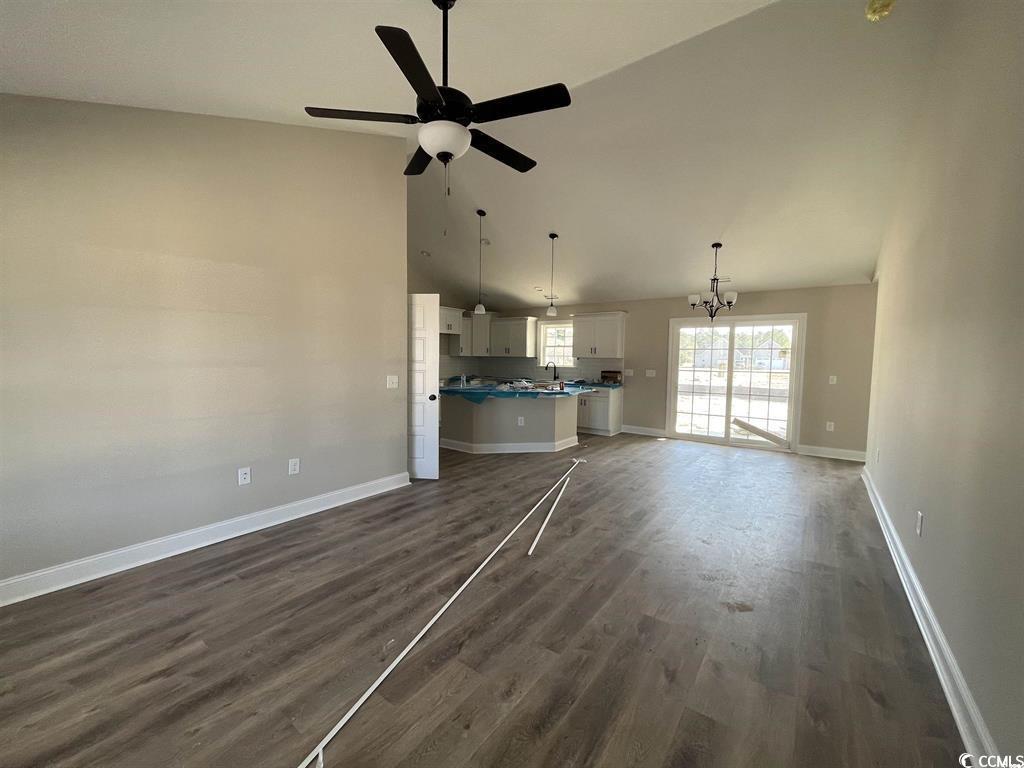 123 Alford Drive Loris, SC 29569 - Photo 3 of 13 Unfurnished living room featuring dark wood-type flooring, a chandelier, high vaulted ceiling, and ceiling fan