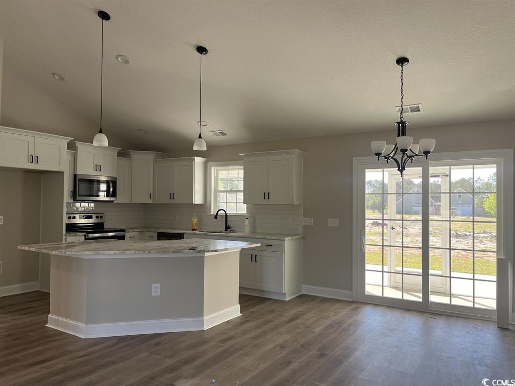 123 Alford Drive Loris, SC 29569 - Photo 7 of 13 Kitchen with decorative backsplash, decorative light fixtures, white cabinetry, stainless steel appliances, and dark wood-type flooring