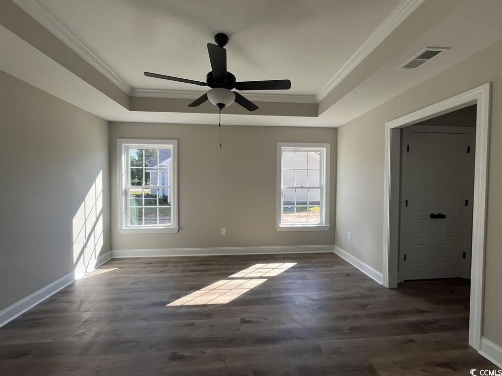 123 Alford Drive Loris, SC 29569 - Photo 8 of 13 Unfurnished room with dark wood-style floors, a raised ceiling, crown molding, and a ceiling fan