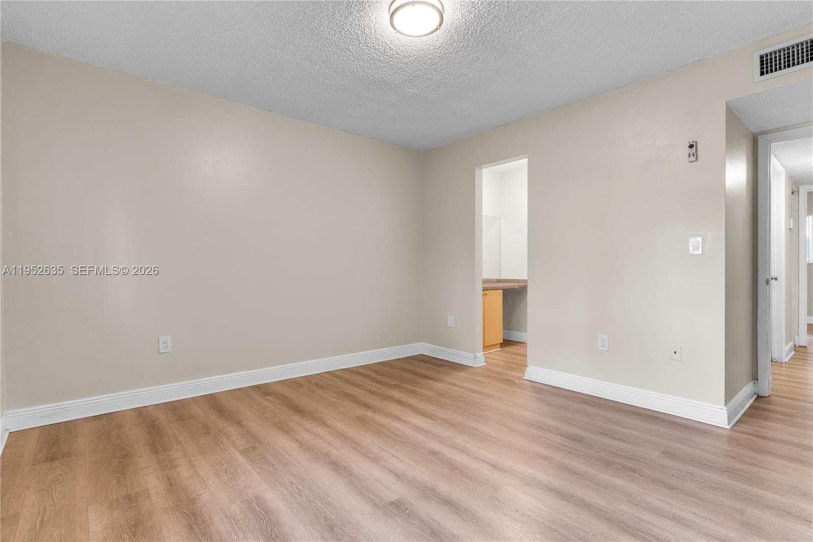 2690 West 76th Street, Unit 104 Hialeah, FL 33016 - Photo 16 of 25 a view of an empty room with wooden floor and a window