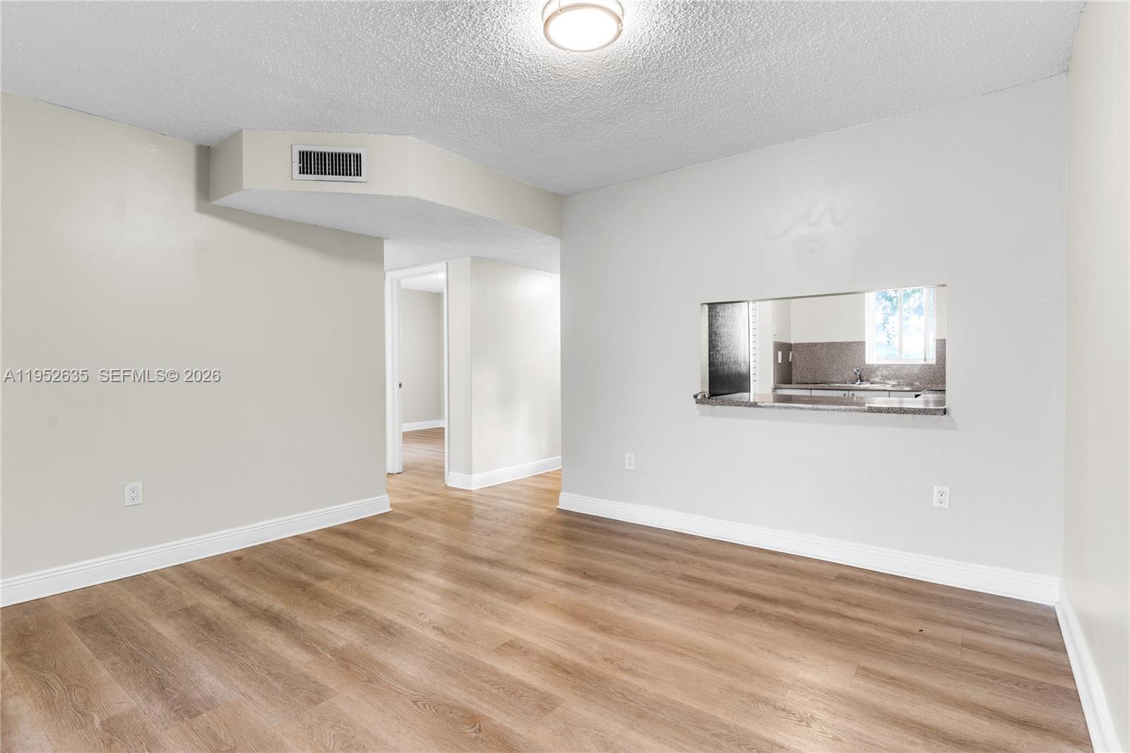 2690 West 76th Street, Unit 104 Hialeah, FL 33016 - Photo 7 of 25 a view of an empty room with wooden floor and a window