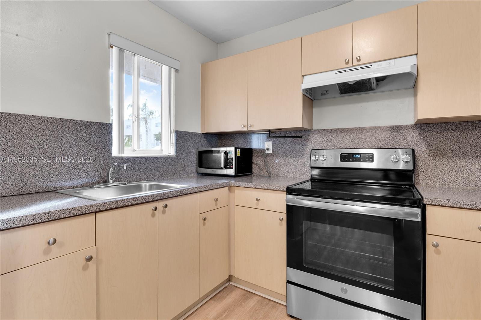 2690 West 76th Street, Unit 104 Hialeah, FL 33016 - Photo 10 of 25 a kitchen with granite countertop white cabinets and appliances