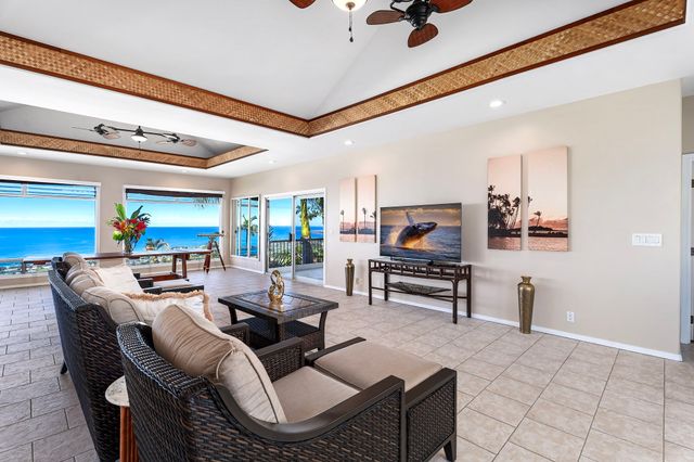 a living room with furniture a rug potted plant and a large window