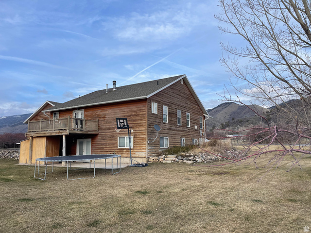 333 Lago Liberty Road Grace, ID 83241 - Photo 5 of 35 Rear view of house with a mountain view, a trampoline, a yard, and a patio