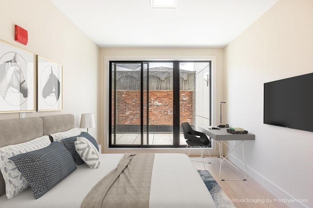 121 Portland Street, Unit 7O8 Boston, MA 02114 - Photo 1 of 40 a bedroom with a bed and a flat tv screen next to a large window