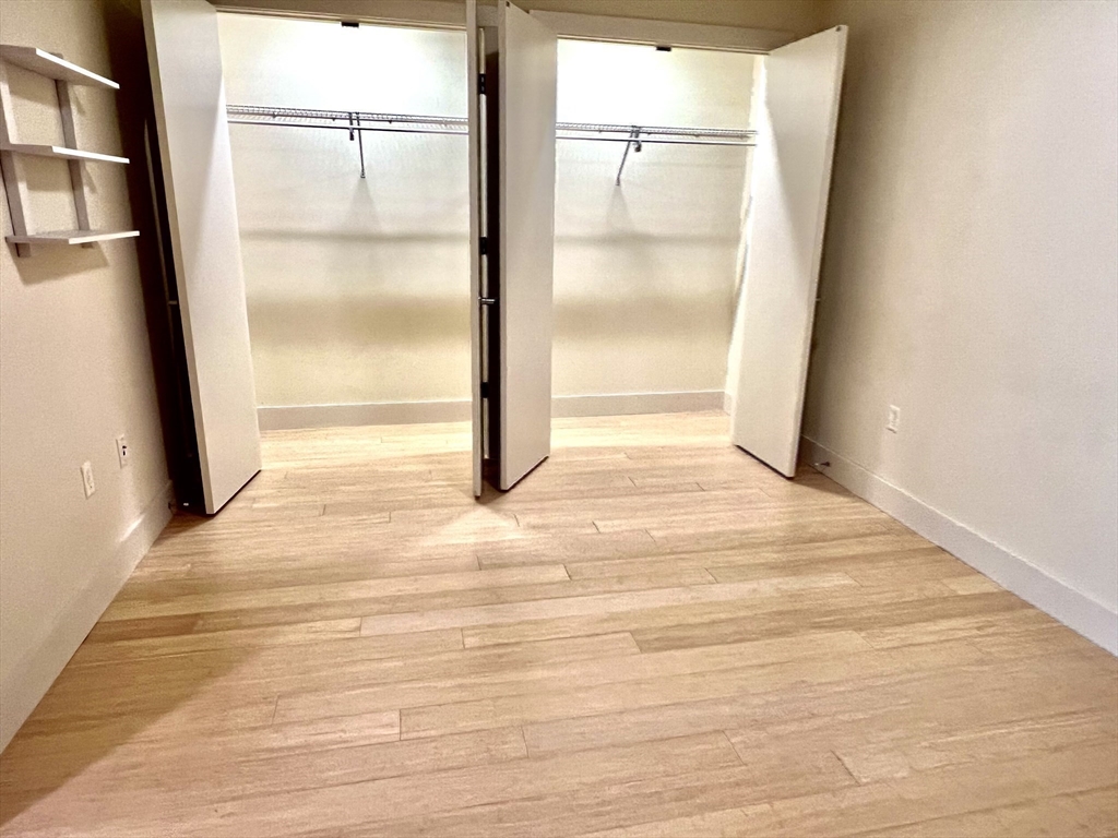 121 Portland Street, Unit 7O8 Boston, MA 02114 - Photo 12 of 40 an empty room with wooden floor and windows