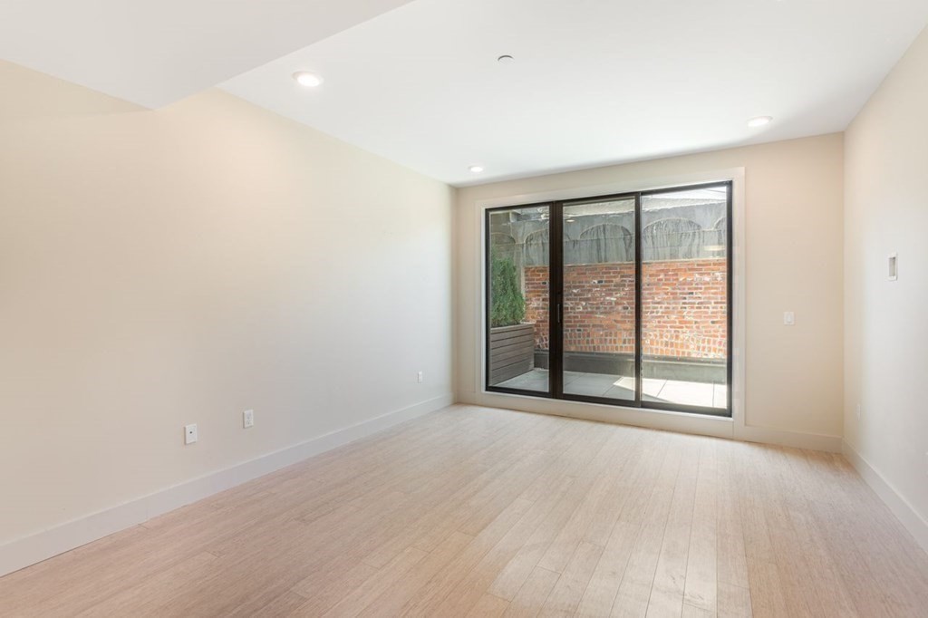 121 Portland Street, Unit 7O8 Boston, MA 02114 - Photo 14 of 40 an empty room with wooden floor and windows