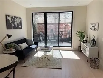 a living room with furniture a rug and white walls