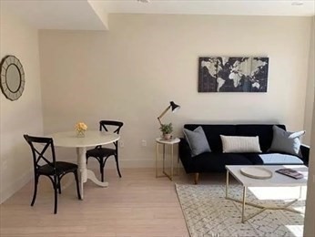 121 Portland Street, Unit 7O8 Boston, MA 02114 - Photo 18 of 40 a living room with furniture a rug and white walls