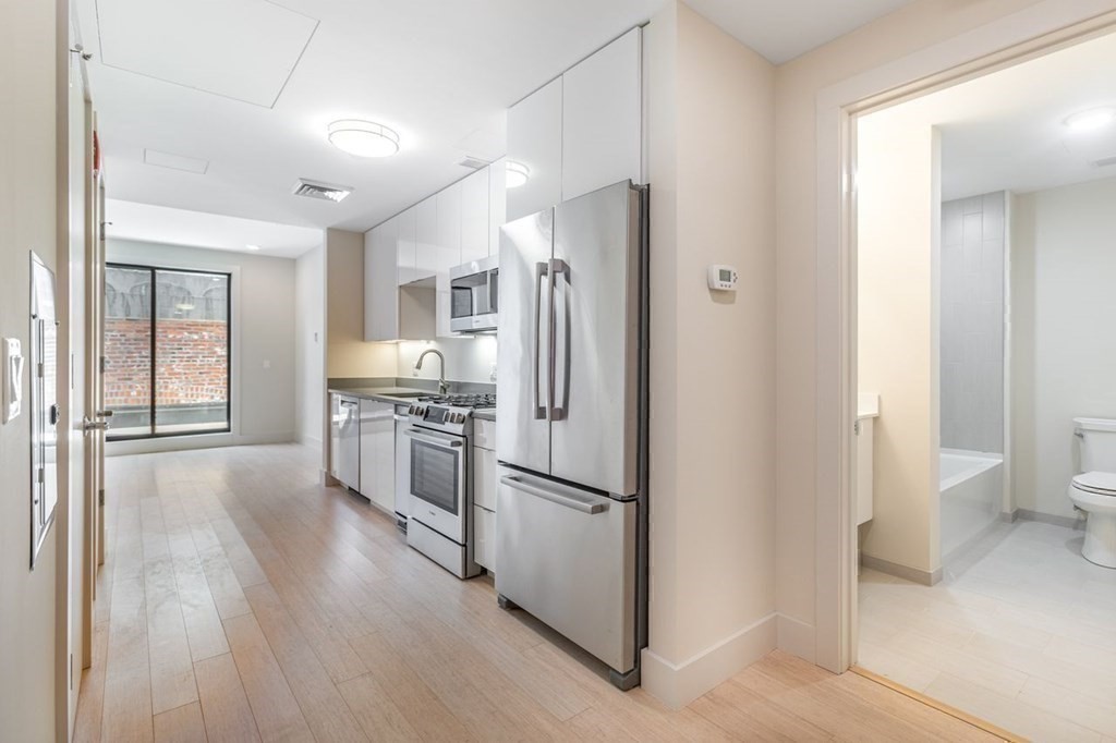 121 Portland Street, Unit 7O8 Boston, MA 02114 - Photo 25 of 40 a kitchen with stainless steel appliances a refrigerator and a stove top oven