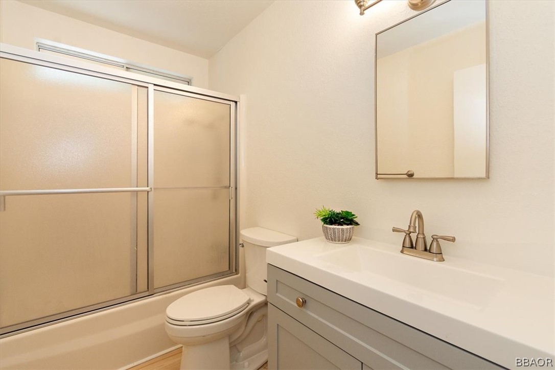420 Lark Road Wrightwood, CA 92397 - Photo 13 of 25 a bathroom with a sink a mirror a toilet and shower