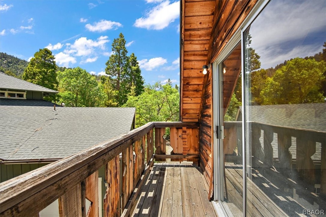420 Lark Road Wrightwood, CA 92397 - Photo 21 of 25 a view of balcony with wooden floor and fence and a couple of potted plants