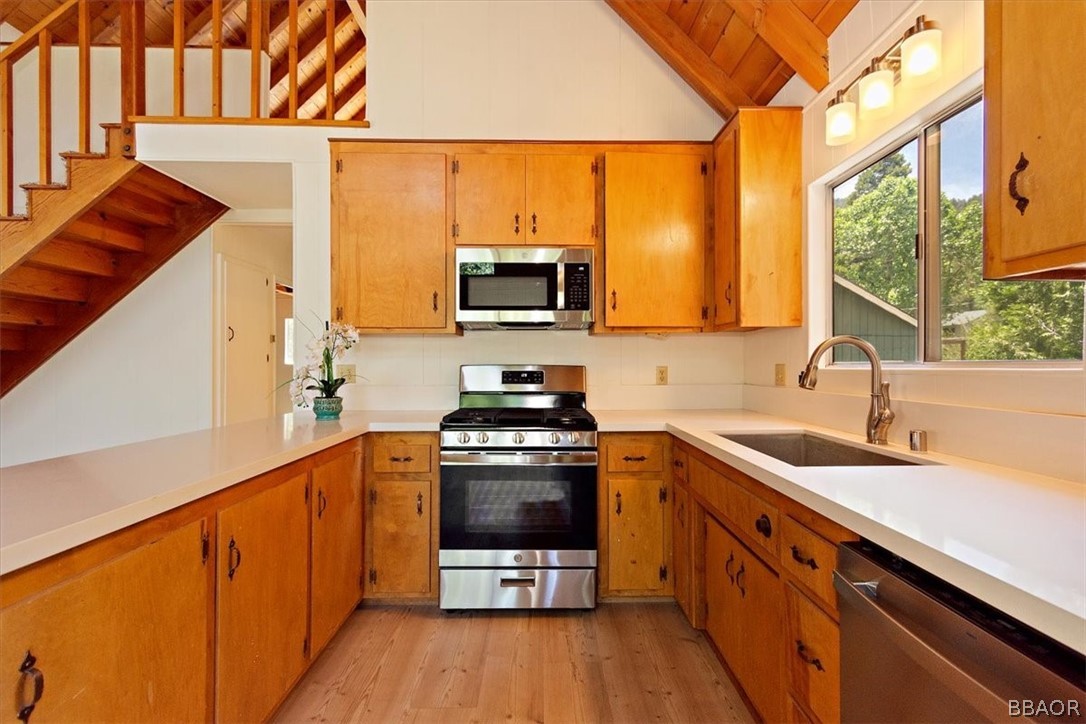 420 Lark Road Wrightwood, CA 92397 - Photo 8 of 25 a kitchen with stainless steel appliances a sink a stove and a wooden floor
