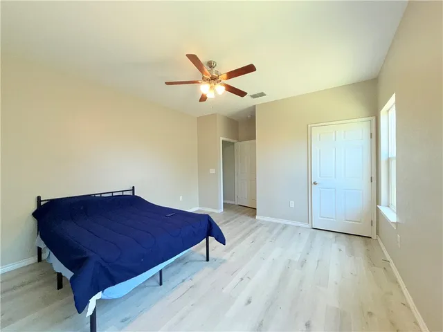 a living room with a bed and a ceiling fan