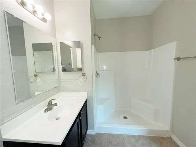 a bathroom with a shower and a sink