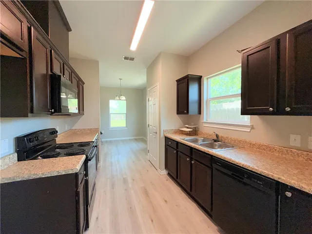 a kitchen with a sink a stove and cabinets