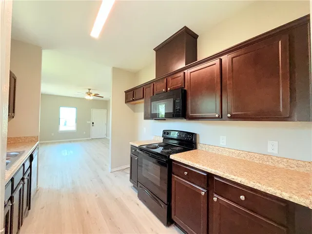 a kitchen with stainless steel appliances granite countertop a sink stove and microwave