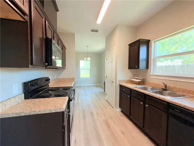 a kitchen with a stove a sink a refrigerator and a microwave