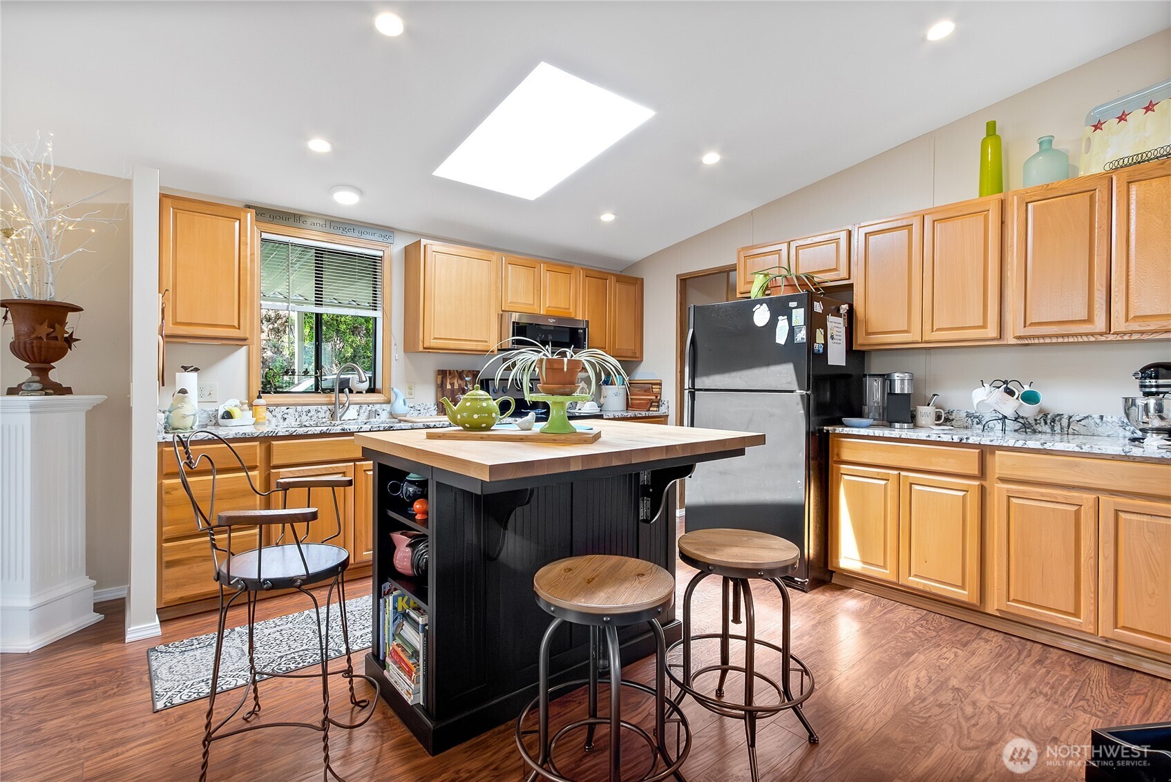 836 Harman Way South, Unit 76 Orting, WA 98360 - Photo 11 of 21 a kitchen with stainless steel appliances kitchen island granite countertop a table chairs sink and cabinets
