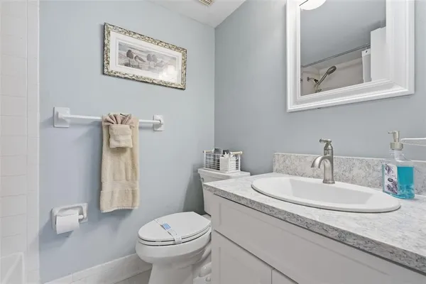 a bathroom with a granite countertop toilet and a sink