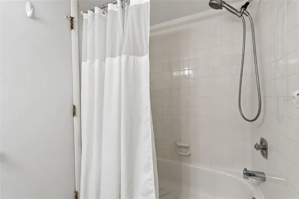 a bathroom with a shower curtain and a shower
