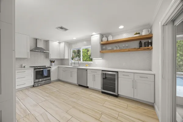 a kitchen with white cabinets and appliances